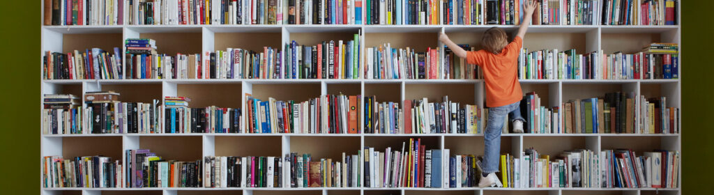 child climbing up bookshelf